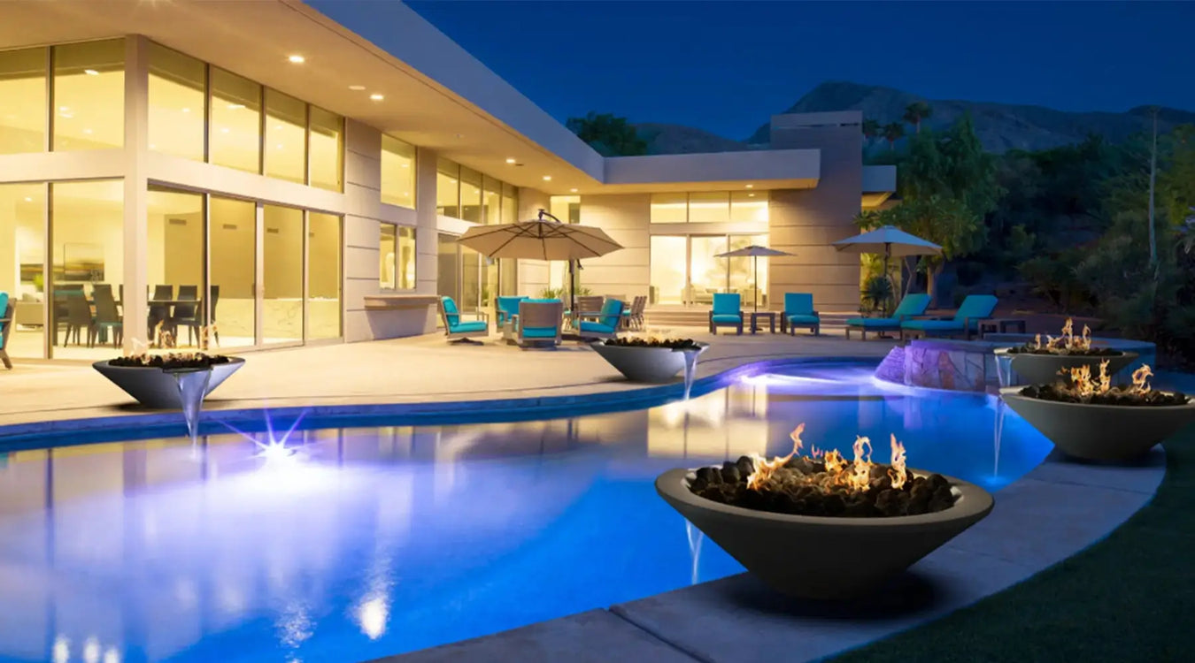 Luxury outdoor space with a glowing pool, surrounded by modern fire bowls, creating a warm ambiance at a contemporary home.