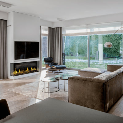 Contemporary indoor fireplace with sleek fire design, set beneath a wall-mounted TV, blending indoor and outdoor views.